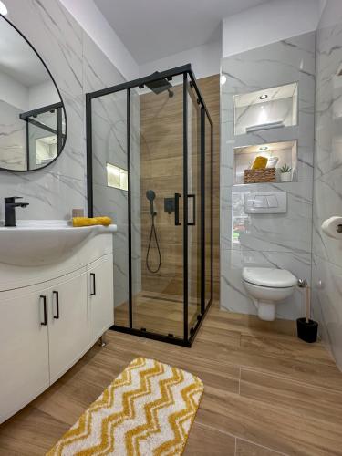 a bathroom with a shower and a sink and a toilet at Apartments Kolovrat in Podstrana