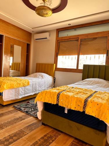 a bedroom with two beds with yellow covers on them at AYOR FES in El Oulaij