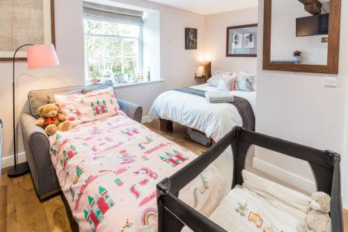 a small bedroom with a bed and a crib at Hall View Guest Suite in Nunnington