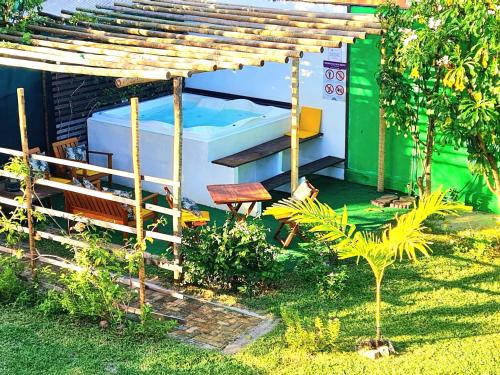 a hot tub sitting under a wooden pergola at Di Pipa Rooms - Hidromassagem Externa in Pipa
