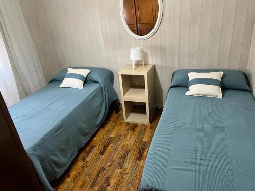 a room with two beds and a table with a mirror at Casa Ángeles in Marín