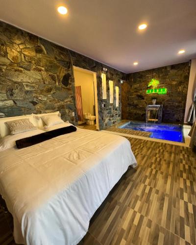 a bedroom with a large bed and a stone wall at Palmar San Gil in San Gil
