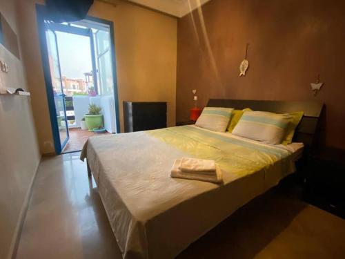 Cette chambre comprend un grand lit et une grande fenêtre. dans l'établissement Appartement COQUILLAGE, à Skhirat
