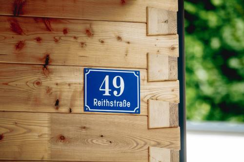 a sign on the side of a wooden wall at Chalet 49 Nesselgraben - Ferienwohnungen aus Holz in Koppl