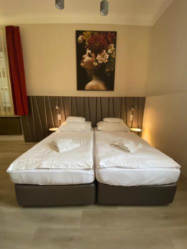 two beds sitting next to each other in a room at Pető Apartman in Győr