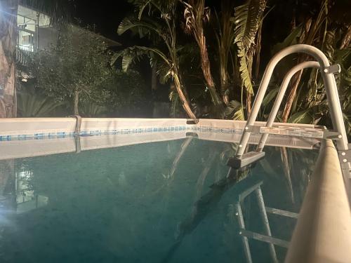 uma piscina à noite com uma escada na água em The King Ross em Santa Venerina