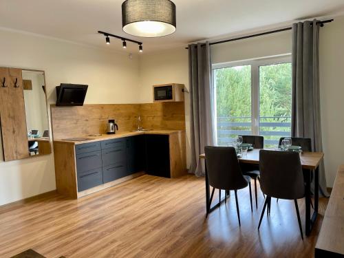 a kitchen and dining room with a table and chairs at Apartamenty MarSyl in Jastrzębia Góra