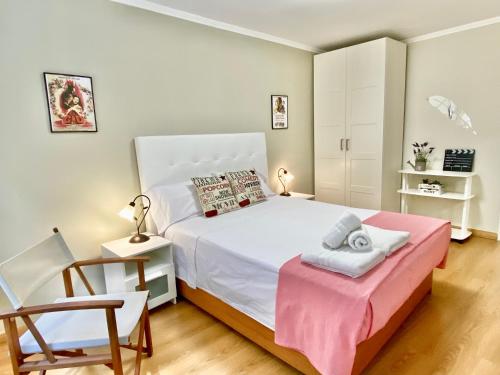 a bedroom with a white bed and a chair at Apartamento en el Centro, 2 dormitorios, junto parking telpark in Almería