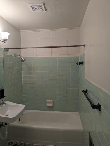 ein Badezimmer mit einem Waschbecken, einer Badewanne und einem Waschbecken in der Unterkunft Pet friendly single story garden condominium in Gulfport