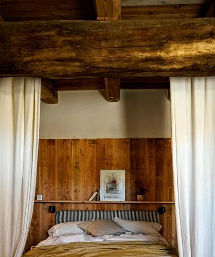 a bedroom with wooden walls and a bed with curtains at CAN TAT, Loft in a old coach house in Sant Jordi Desvalls