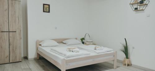 uma cama branca com duas almofadas num quarto em Sunčani apartman 1 em Krupanj