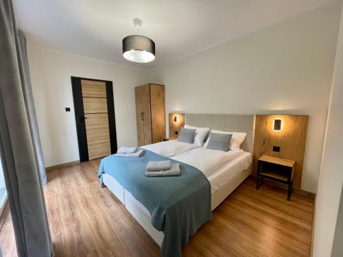a bedroom with a large bed with a blue blanket at Apartamenty MarSyl in Jastrzębia Góra