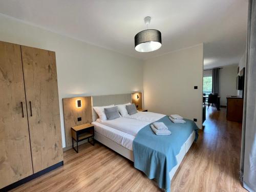 a bedroom with a large bed with a blue blanket at Apartamenty MarSyl in Jastrzębia Góra