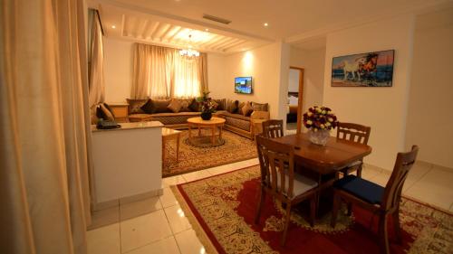 a living room with a table and a couch at El Olivar Palace Marrakech All Inclusive, Aquapark & SPA in Marrakech