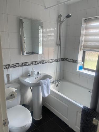 a bathroom with a sink and a tub and a toilet at 2 bed house, walking distance Shrewsbury centre in Shrewsbury