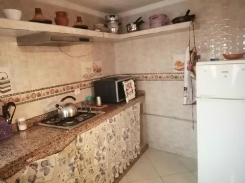 a small kitchen with a stove and a refrigerator at appartement traditional cozy in Tangier