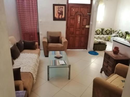 a living room with a couch and chairs and a door at appartement traditional cozy in Tangier