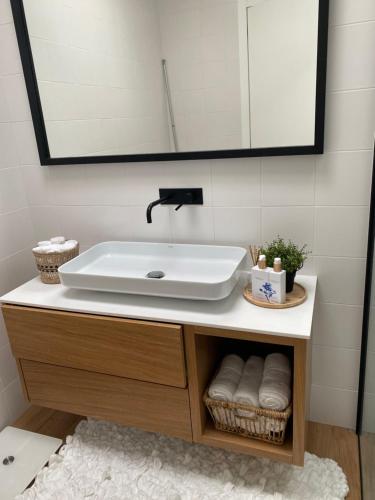 W łazience znajduje się umywalka i lustro. w obiekcie PEARL by Balgrid w mieście Viana do Castelo