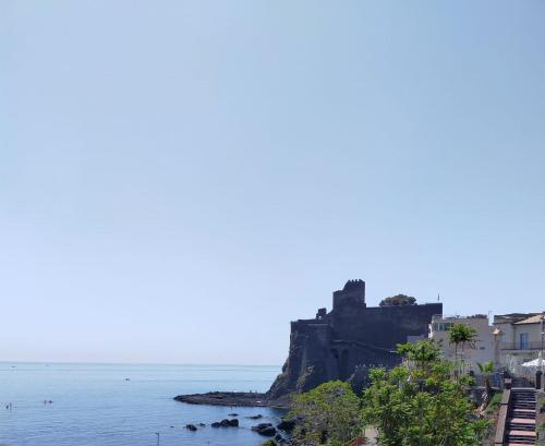an island in the water with a castle on it at Casa Kalé in Aci Castello