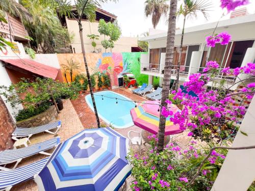 a patio with umbrellas and a swimming pool at ITH Sayulita Amazing Surf Hostel in Sayulita