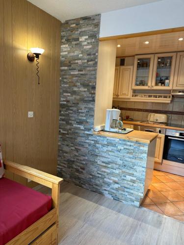 a kitchen with a counter and a brick wall at T2 spacieux lumineux TIGNES VAL CLARET in Tignes