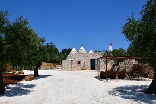 a stone building with a pavilion in front of it at Trulli di Titti - Luxury Country House in Castellana Grotte