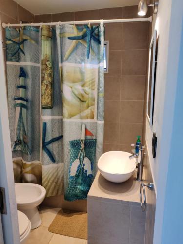 a bathroom with a sink and a shower curtain at Luz de Faro, frente a las playas mas lindas! in Mar del Plata