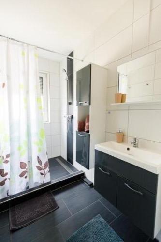 a bathroom with a shower curtain and a sink at Ferienwohnung Dreiländereck in Rheinfelden