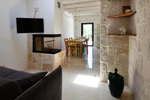 - un salon avec un canapé et une cheminée dans l'établissement Trulli di Titti - Country House, à Castellana Grotte