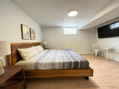 a bedroom with a bed and a flat screen tv at Letitia Heights !A Spacious and Quiet Private Bedroom with Shared Bathroom in Barrie