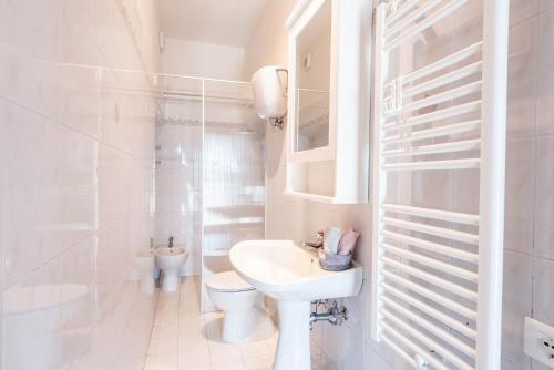 APPARTAMENTI LE GINESTRE 10 في مورلو: حمام أبيض مع حوض ومرحاض