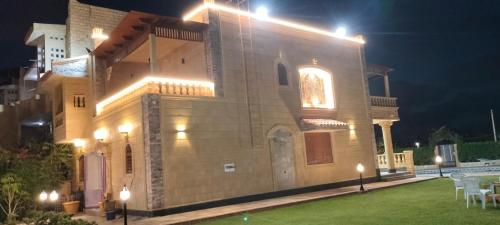 a building with lights on top of it at night at فيلا للايجار في مارينا 4 حمام سباحة خاص in El Alamein