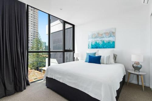 a bedroom with a large bed and a large window at Burleigh Beach Escape with Stunning Sunset Views in Gold Coast