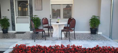 stół i krzesła przed domem pełnym kwiatów w obiekcie Kariofilli's house w mieście Ayios Athanasios