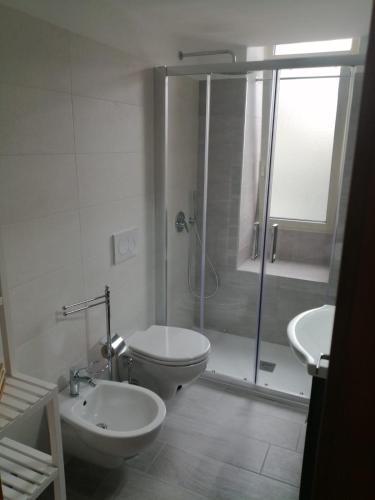 a bathroom with a shower and a toilet and a sink at CA12 casa vacanze in Putignano