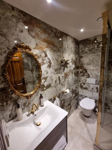a bathroom with a sink and a mirror and a toilet at Masia Cal Lloa in Albinyana