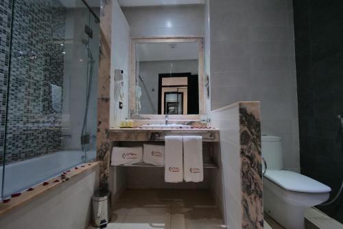 a bathroom with a sink and a toilet and a mirror at El Olivar Palace Marrakech All Inclusive, Aquapark & SPA in Marrakech
