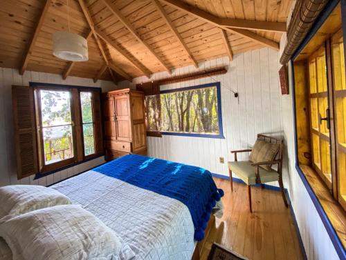 um quarto com uma cama e uma cadeira num quarto em Cabañas Casa en La Montaña em El Canelo