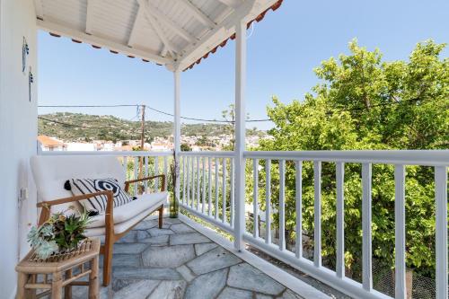 porche blanco con silla y vistas en Yianna Sunny Studios, en Skopelos Town