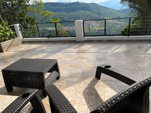 two chairs and a table on a balcony with a view at Palmar San Gil in San Gil