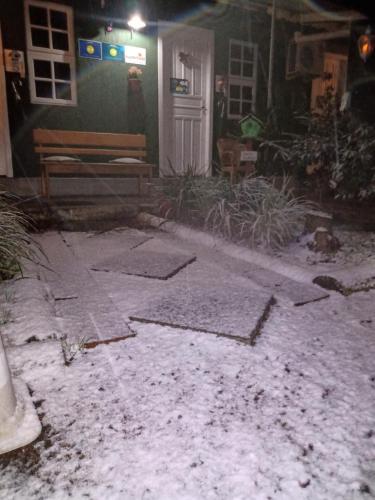 a house with snow on the ground in front of a door at Hospedagem Da Laranjeira Gramado in Gramado