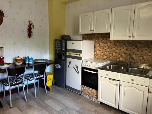 カウローニア・マリーナにあるLo Statere d' Argentoの白いキャビネット、シンク、冷蔵庫付きのキッチンが備わります。