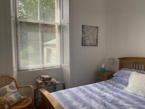 a bedroom with a bed and a window at Lovely main door 2 bed apartment in Edinburgh