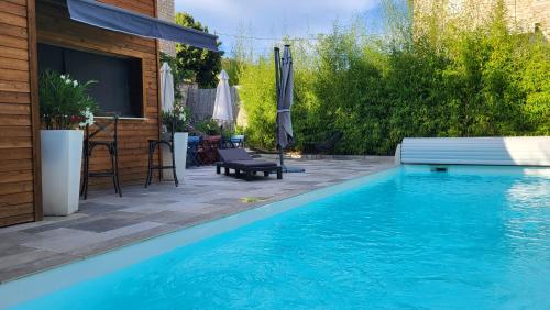 einen Pool vor einem Haus mit einer Terrasse in der Unterkunft Le mas ROLLAND - Piscine & SPA - MILLAU-GORGES du TARN in Compeyre