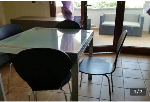 a glass table and two chairs in a room at Relax al Mare in Olbia