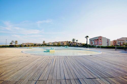 Un grand cercle dans un parc avec des bâtiments en arrière-plan dans l'établissement Maison gde terr. front de mer - 4 couchages, à Leucate
