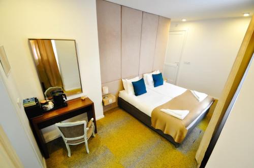 um quarto de hotel com uma cama e um espelho em Heritage Hotel Petrakija em Saraievo