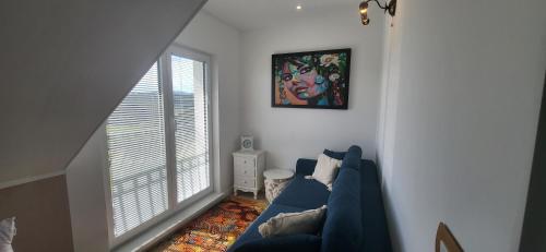 a living room with a blue couch and a window at Villa Hojnik in Videm pri Ptuju