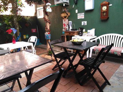 a patio with tables and chairs and a clock at Hospedagem Da Laranjeira Gramado in Gramado