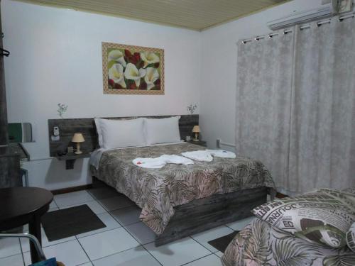a bedroom with a bed with towels on it at Hospedagem Da Laranjeira Gramado in Gramado
